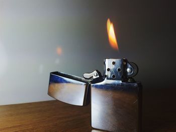 Close-up of illuminated cigarette lighter on table