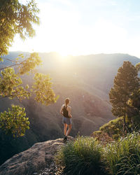 Woman standing on mountain against sky