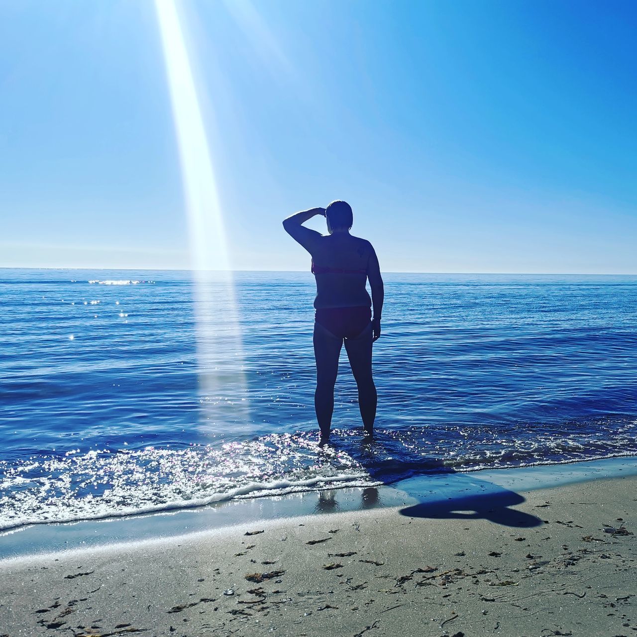 FULL LENGTH REAR VIEW OF MAN STANDING ON BEACH
