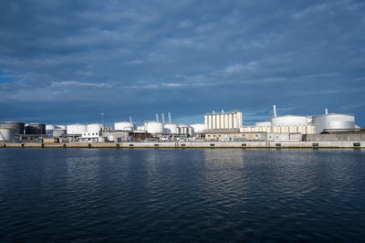 Buildings by sea against sky