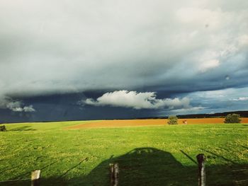 Scenic view of field against cloudy sky