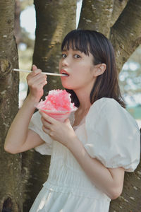 Young woman looking away while holding ice cream