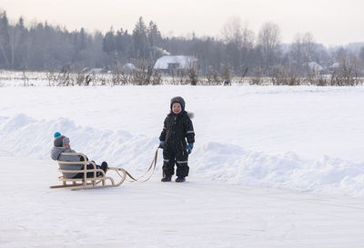 Little kids enjoy a sleigh ride. child sledding. family vacation on christmas eve outdoors