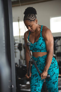 Sporty woman exercising pulley in studio. for arm and shoulder muscles. 