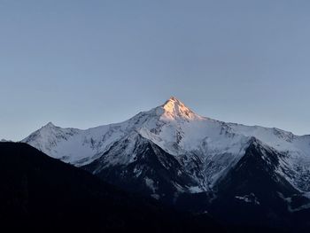 Scenic view of snowcapped mountains against clear sky