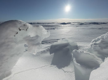 Snow on sea shore against sky