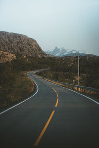 Empty road by mountain against sky