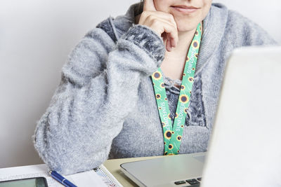 Midsection of woman using laptop on table