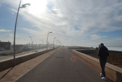  rearw of man walking on road against sky during sunset temara morocco