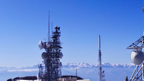 Low angle view of communications tower against blue sky