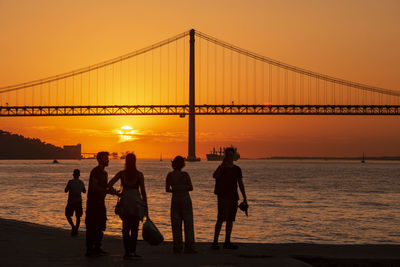 Silhouette people on beach during sunset