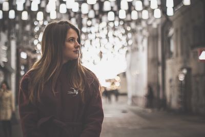 Portrait of young woman standing in city