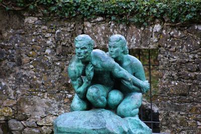 Close-up of statue against stone wall