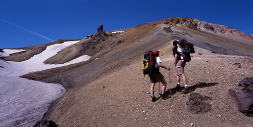 Two hikers hiking up a mountain in landmannalaugar