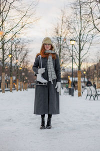 Rear view of woman standing on snow covered field