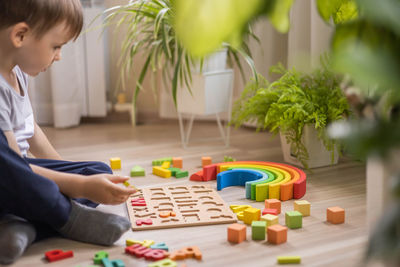 Midsection of boy playing with toy blocks at home