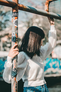 Rear view of woman holding umbrella