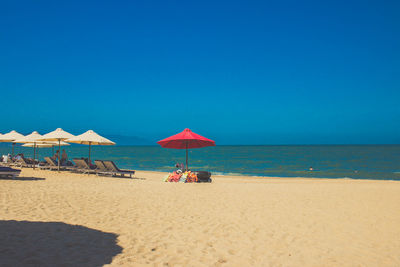 Scenic view of beach against clear blue sky