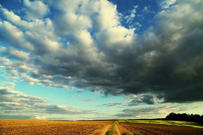 Scenic view of field against storm clouds
