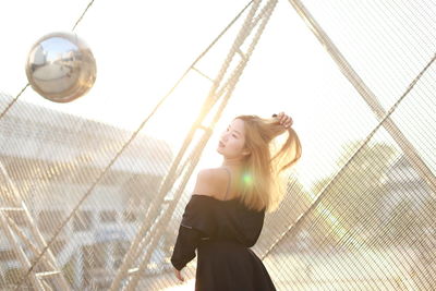 Rear view of woman looking through window