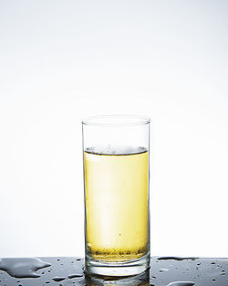 Close-up of beer glass on table against white background