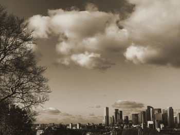 Buildings in city against cloudy sky