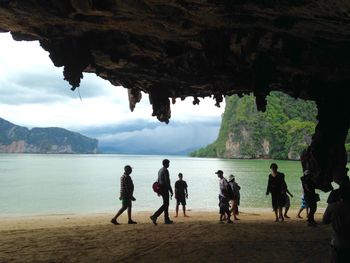 Group of people by cave at beach