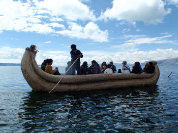 People in boat on sea against sky