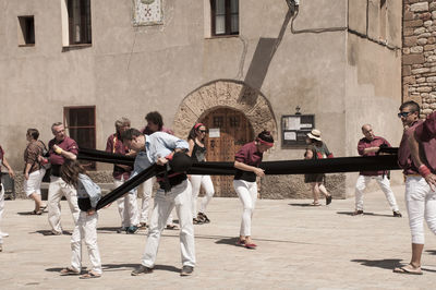 People playing in park against buildings