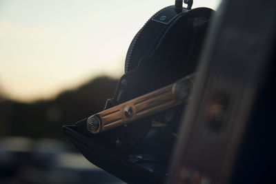 Close-up of camera against sky during sunset