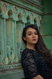 Portrait of woman standing against wall