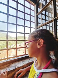 Close-up of girl looking away through window