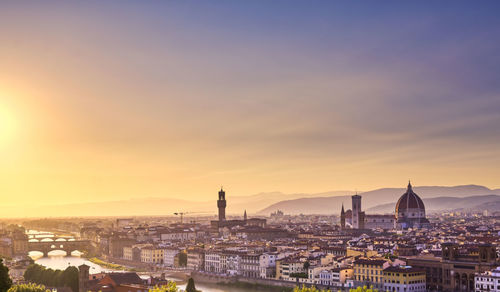 Buildings in city at sunset