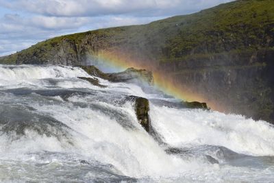 Scenic view of waterfall against sky