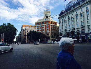 Rear view of a man walking in front of buildings