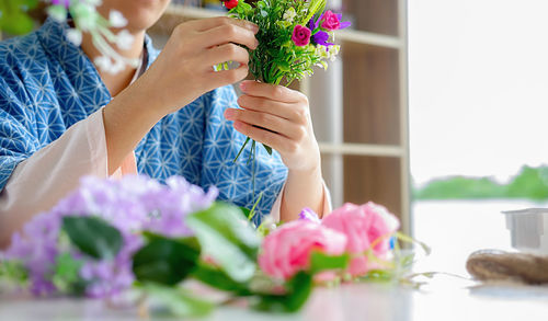 Midsection of woman holding flower bouquet