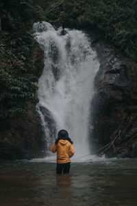 Rear view of man standing on rock