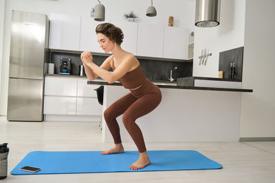 Side view of woman exercising in gym