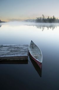 Red canoe and fog and mists on the lake vertical