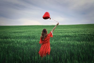 Rear view of woman standing on field