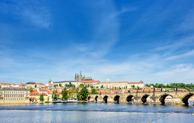 Arch bridge over river against buildings in city