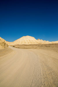 Scenic view of desert against clear blue sky