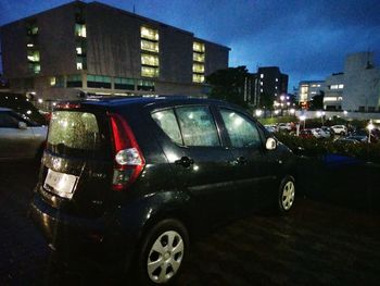 Close-up of car against illuminated city at night