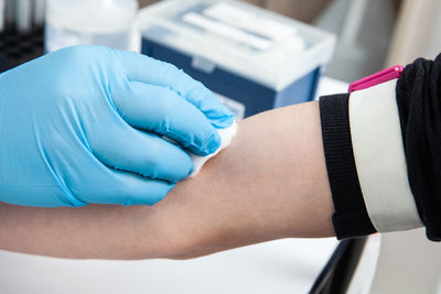 Nurse disinfecting a patient's arm before taking a blood sample