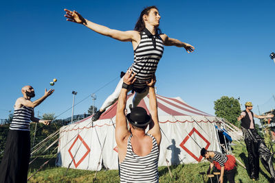 Circus acrobats and artists performing together in front of tent