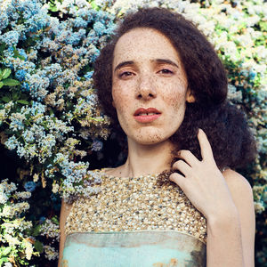 Portrait of woman with freckles on face against plants