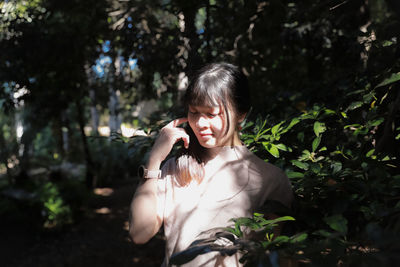 Side view of young woman sitting on field