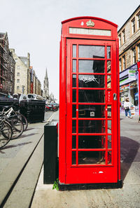 Red telephone booth on street in city