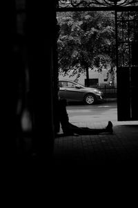 Silhouette man sitting on street in city