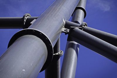 Low angle view of metal against blue sky